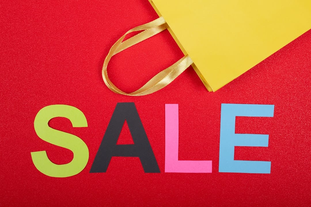Colorful letters spelling "SALE" on a red background with a yellow shopping bag, perfect for those seeking fast transactions.